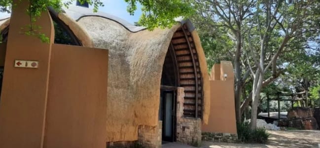 A closer view of the lodge's sculpted, curved thatch doorway.